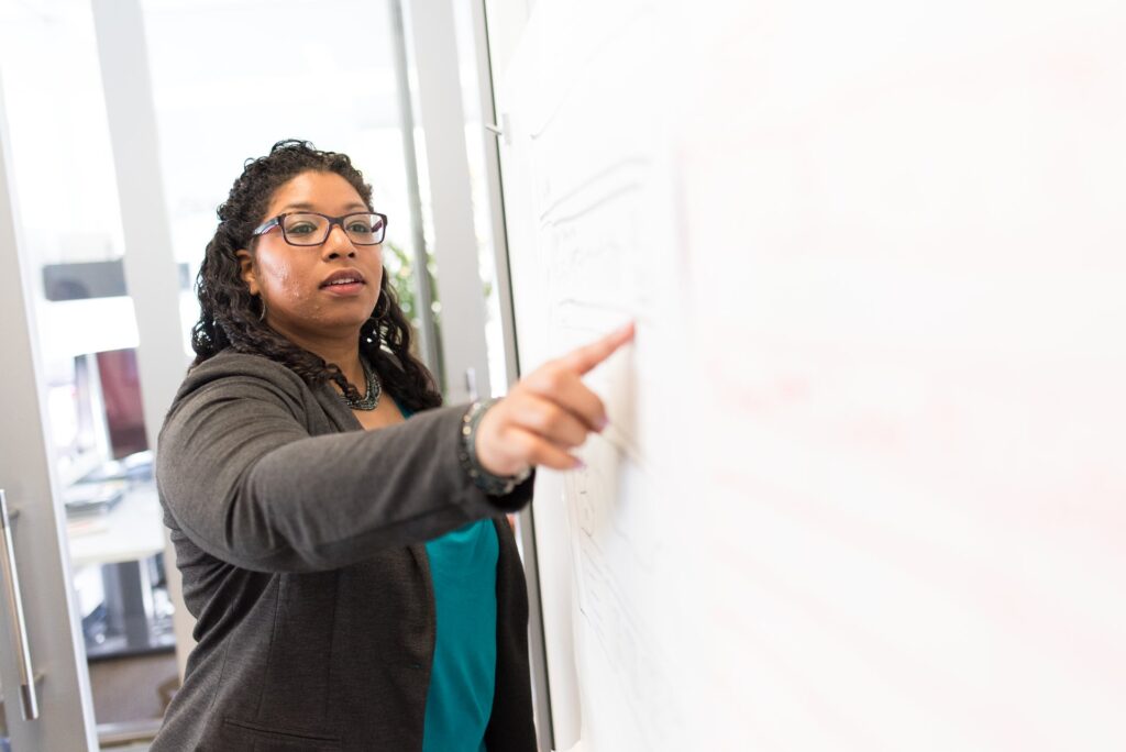 A trainer pointing to notes on a whiteboard during a session